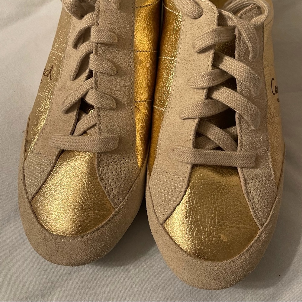 Coach “Reina” Gold Sneakers.  Preowned in good condition .  Size 9